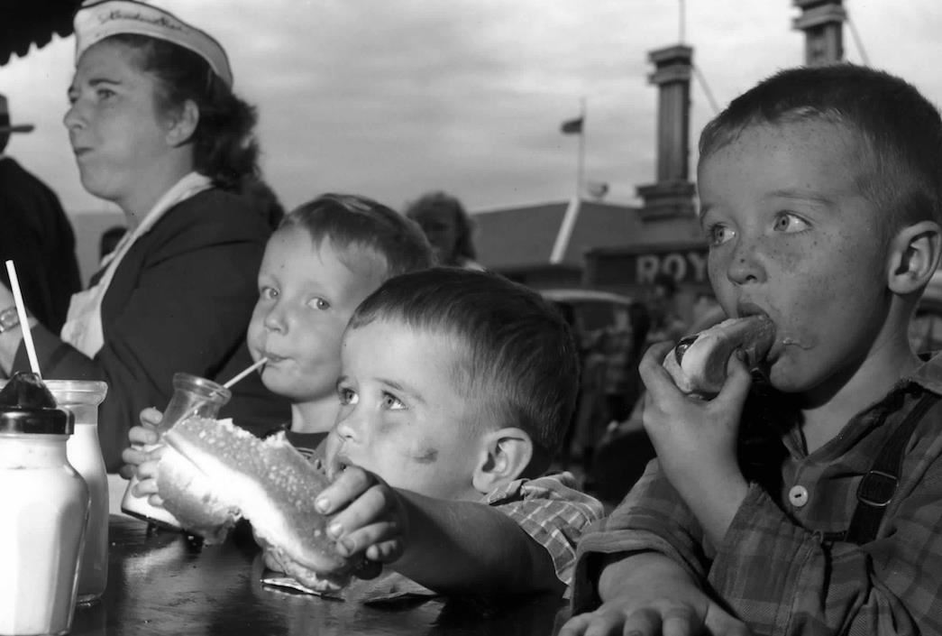 historical photo of children eating hot dogs