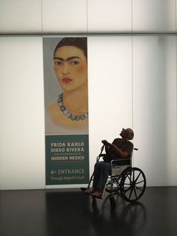 woman in wheelchair and Frida Kahlo banner