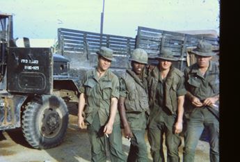 US soldiers in front of supply convoy trucks in Vietnam