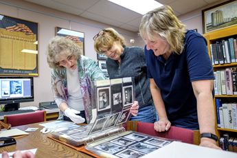 Ladies looking at photos for preservation project