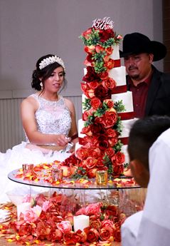 Young girl cuts Quinceañera cake