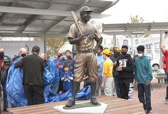Jackie Robinson statue at Wichita's McAdams Park surrounded by people.