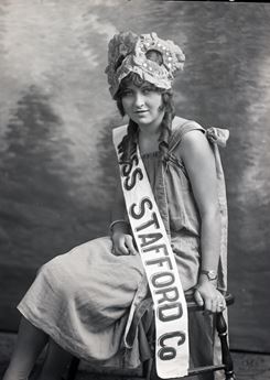 historic photo of young woman wearing a Miss Stafford banner