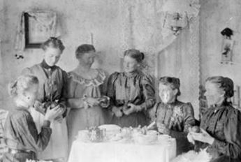women sitting around table peeling fruit