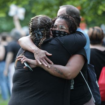 Two protestors hug