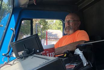 Man sitting in cab of sanitation truck