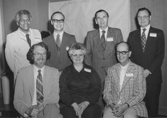 Group photo of men and women seated and standing