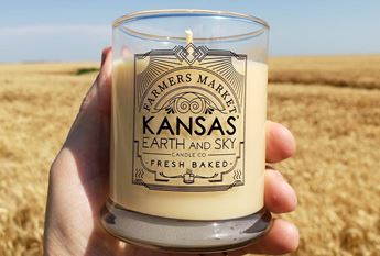 hand holding candle by field