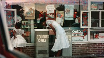 woman drinking at colored only water fountain