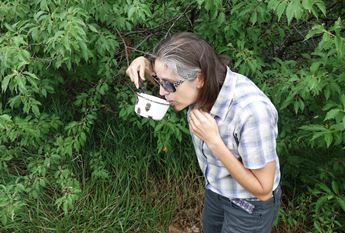 Christy Davis sips Flint Hills water straight from the source using a ladle at an artesian well.
