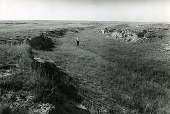 A man stands in the middle of the dry bed of the Soule Canal