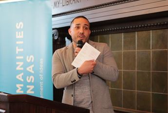 Huascar Medina reading poetry at event in Topeka