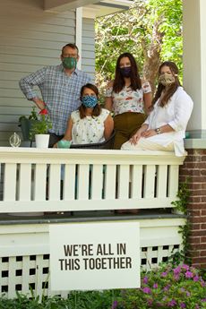 family on porch wearing mask
