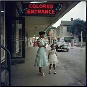 a woman and young girl by colored entrance sign