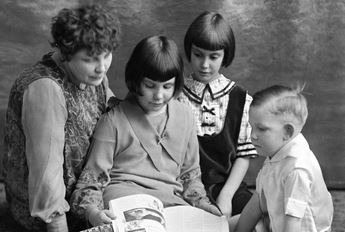 mother and children looking at magazine