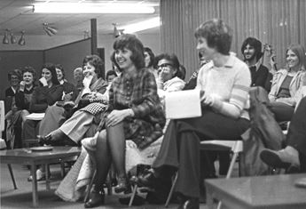 women and men listening to a speaker