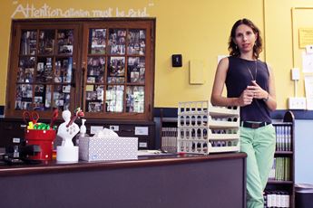 Kirsten Cigler-Nelson standing by her desk in her classroom