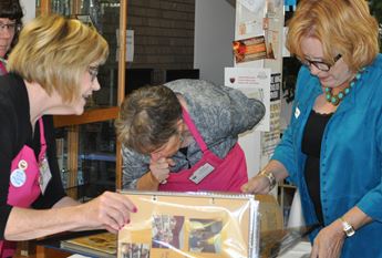 Three women looking at scrapbook