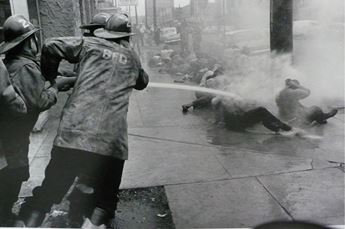 Fireman blasting demonstrators with hose