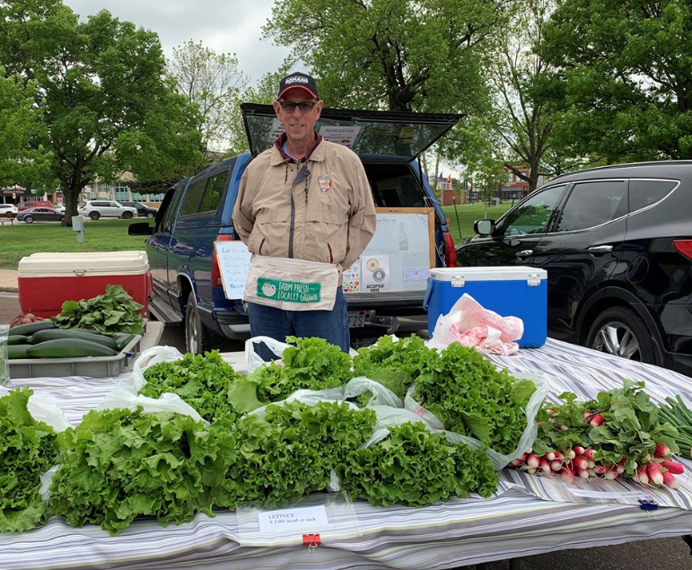 man selling vegetables at a farmers market