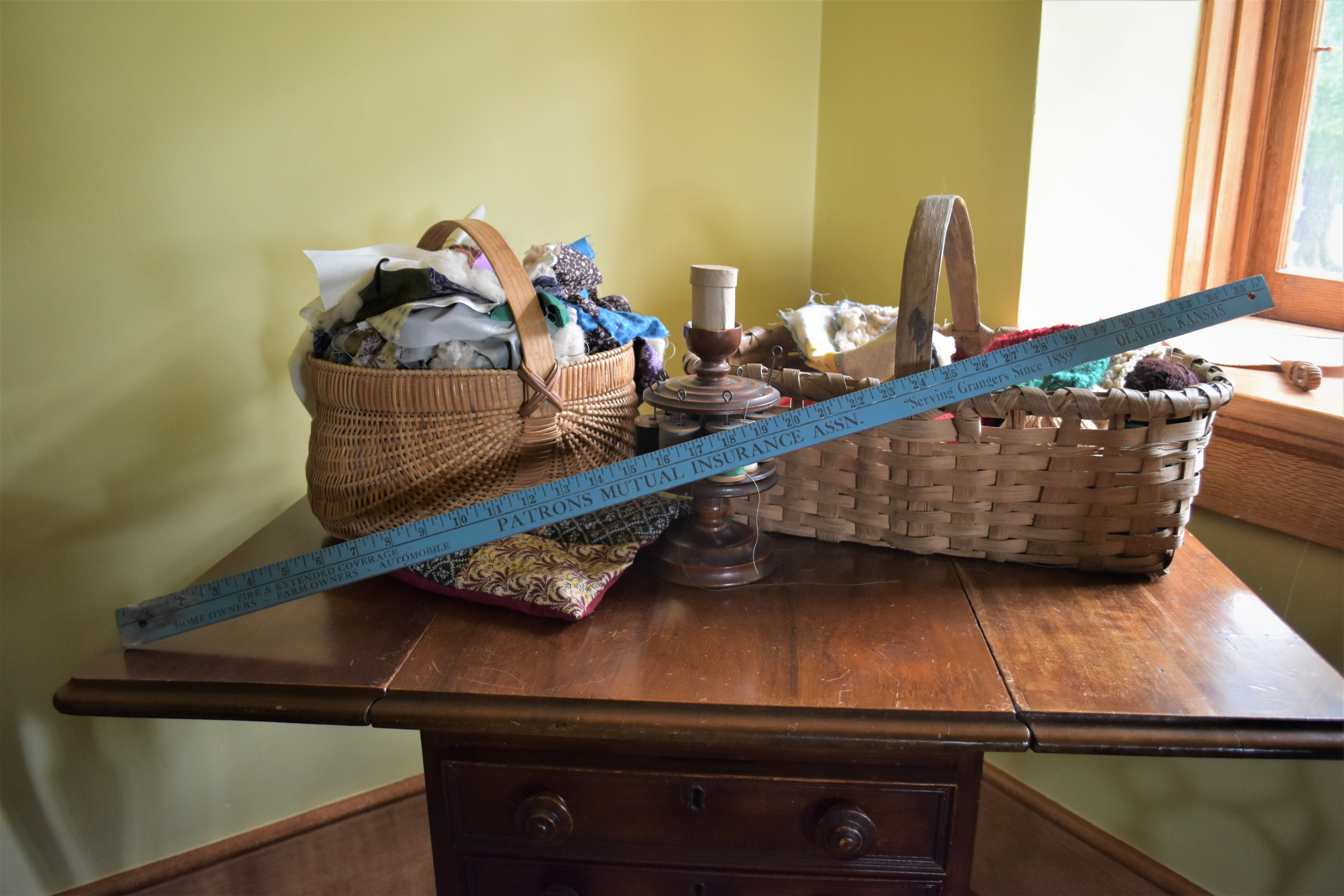 blue yardstick in front of sewing baskets