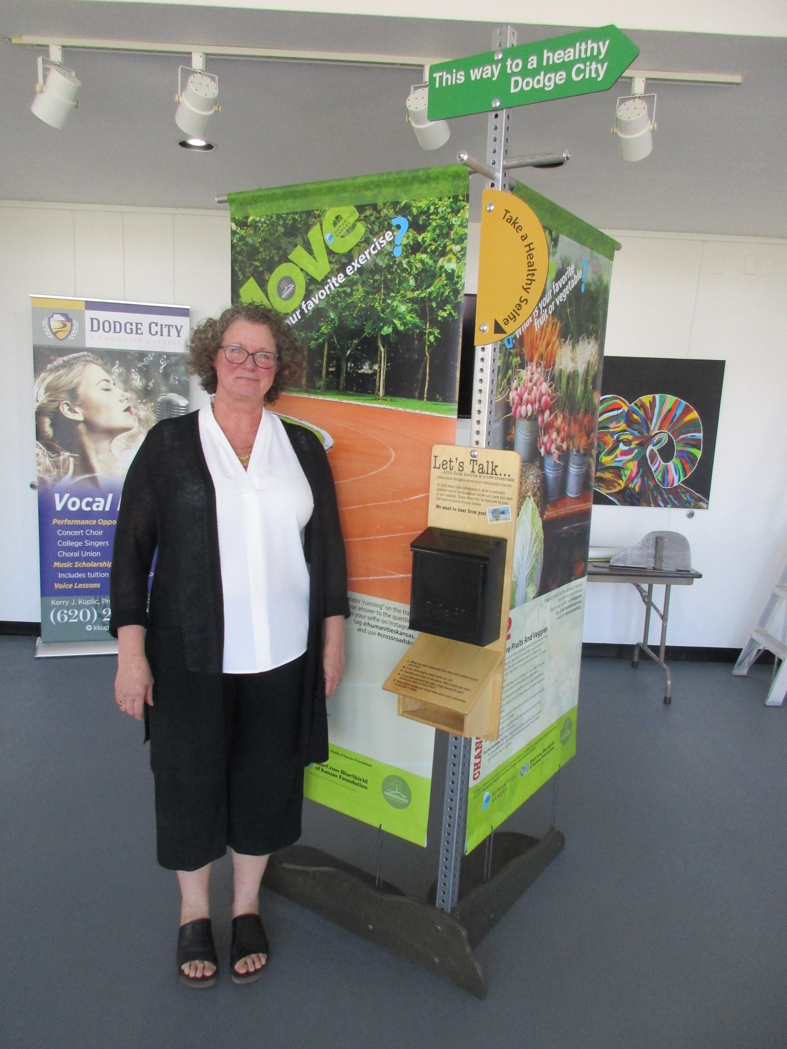 HK board member stands next to Healthy Behavior kiosk at Dodge City Community College.